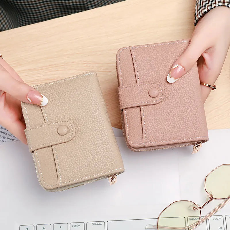 A compact beige ladies' short wallet with a textured lychee pattern, shown folded.