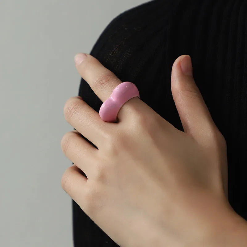Colourful three-dimensional heart-shaped enamel ring in zinc alloy on a hand.