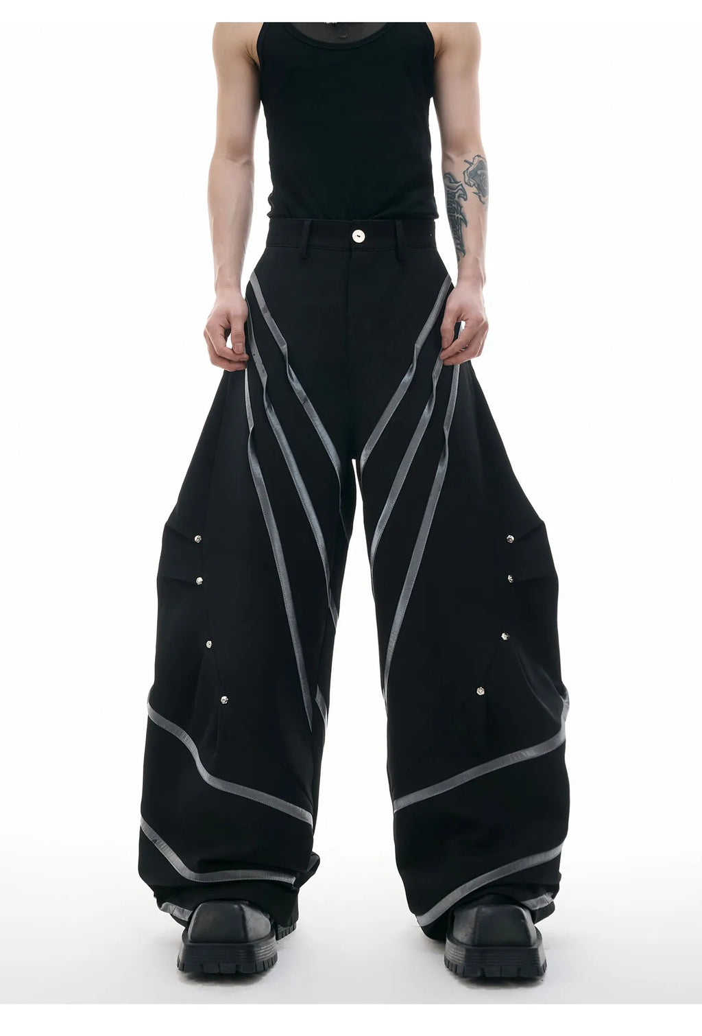 Men's black polyester trousers with metal rivet stripe and front pleats on a white background.