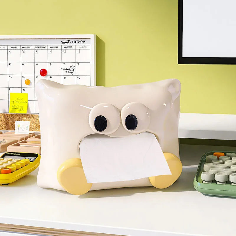 A white ceramic tissue box holder on a wooden coffee table.