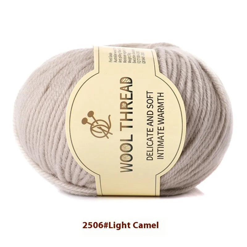 One roll of beige domestic wool hand-knitting yarn for size 10 needles next to knitting needles.