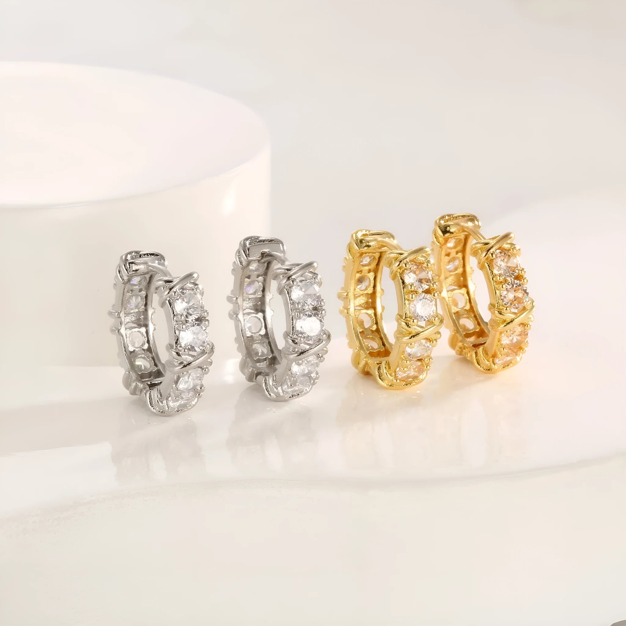A pair of geometric hexagonal clover cross earrings with an elliptical shape in a gold or silver electroplated finish.