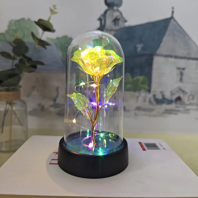 Small decorative night lamp with plastic flowers and a glass-style cover on a black base.