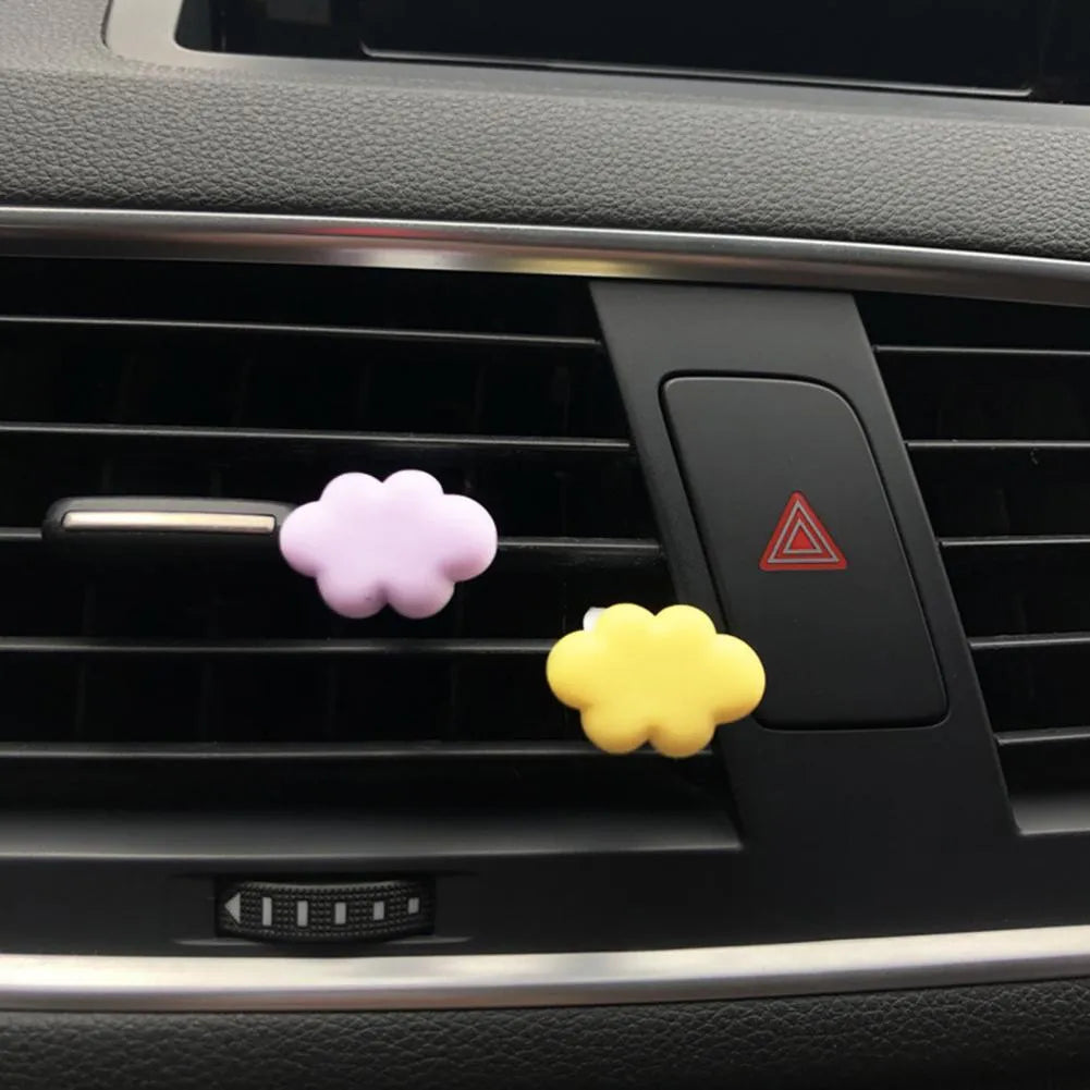 Resin cartoon-style car fragrance clip attached to a vehicle air vent.