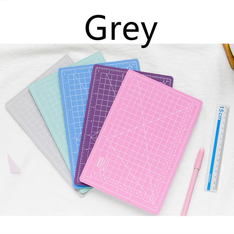 Art pen knife cutting board set showing plastic mat, metal ruler, sharpener and blade in assorted colours.