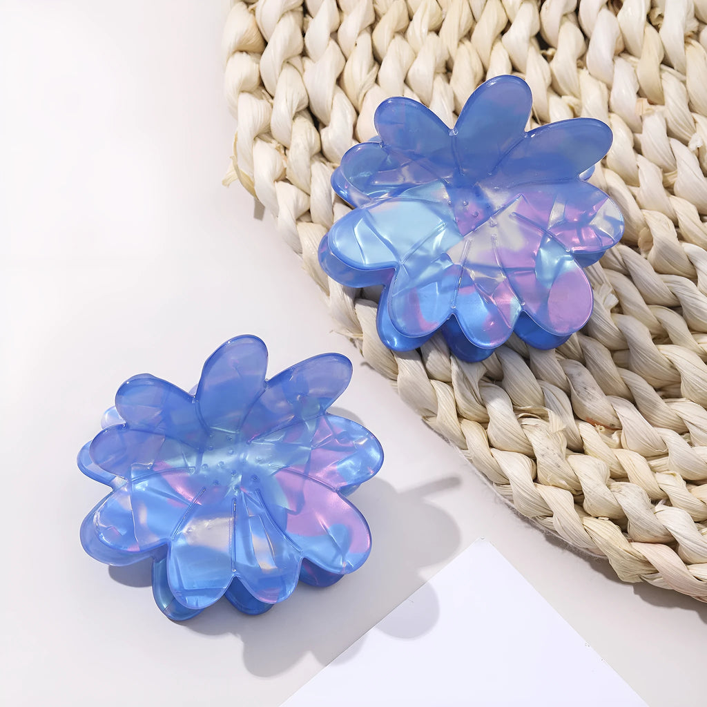 Dazzling blue PVC flower hair clip with glossy finish, 6cm length, on a light background
