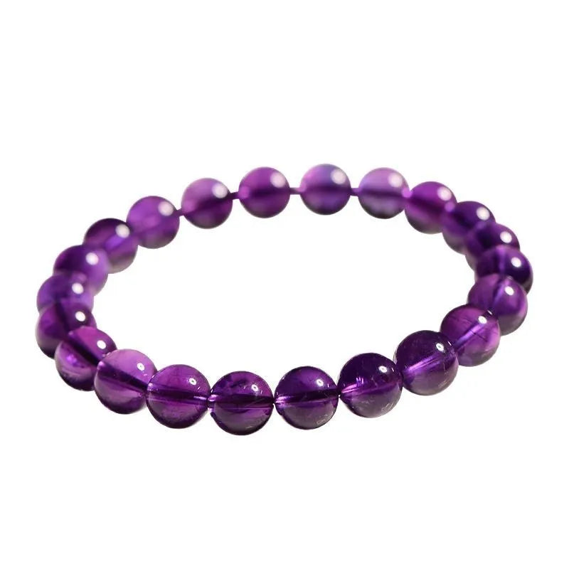 Close-up of a polished natural amethyst bead bracelet with a sliding knot closure on a wrist.