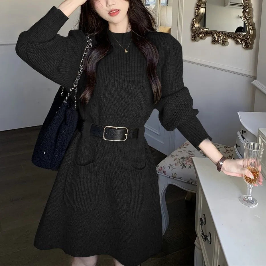 Women's beige long sleeve loose knit dress with a black belt on a hanger.
