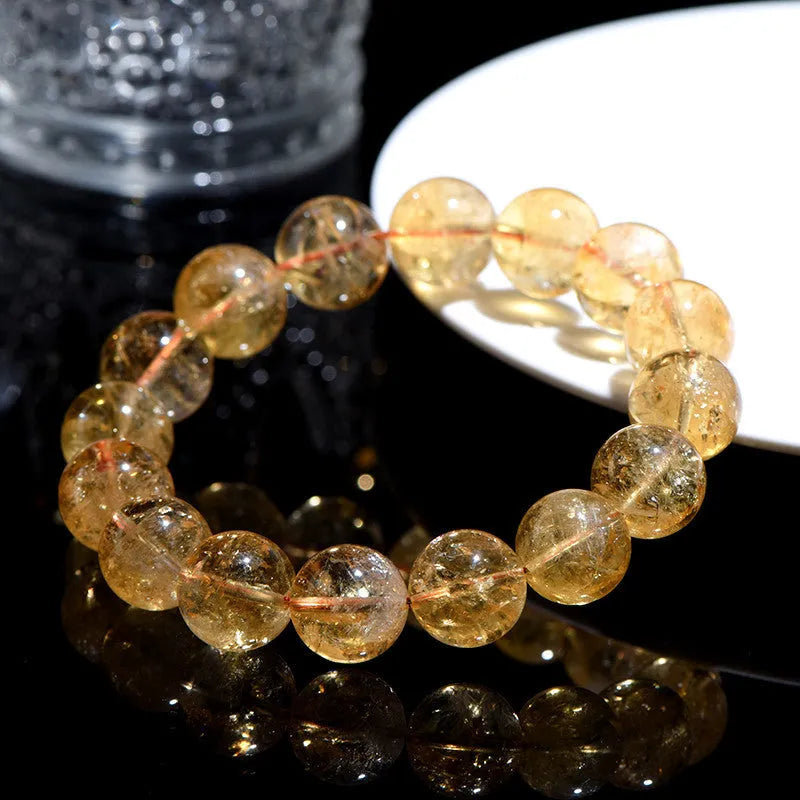 Natural yellow citrine bracelet with geometry-shaped beads in various sizes on a wrist.