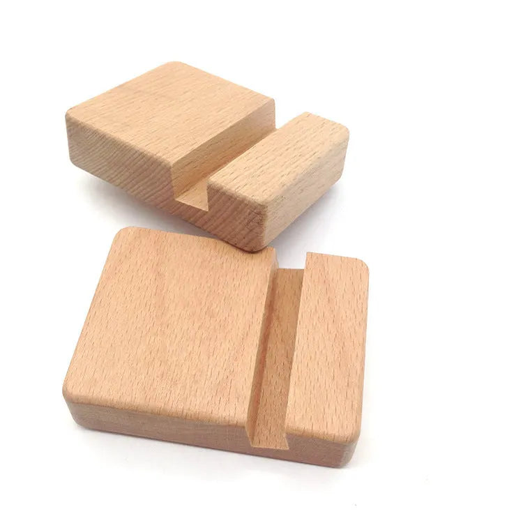 Sculpted beech wood lazy bracket phone holder with custom engraved text on a wooden desk.