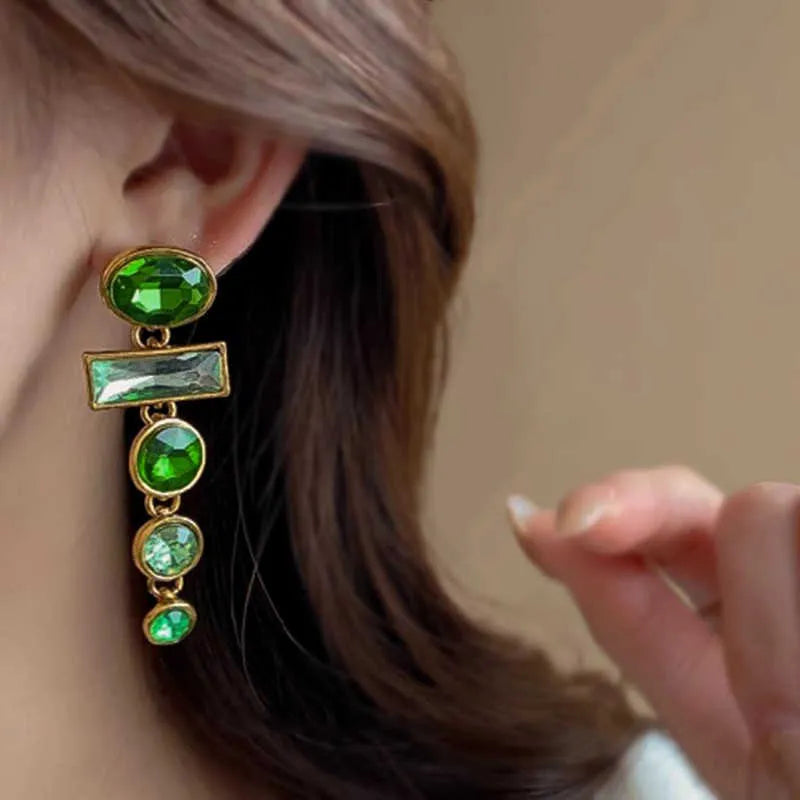 Green gradient geometric alloy earrings with a long tassel and sparkling inlaid zircon centre on a white background.