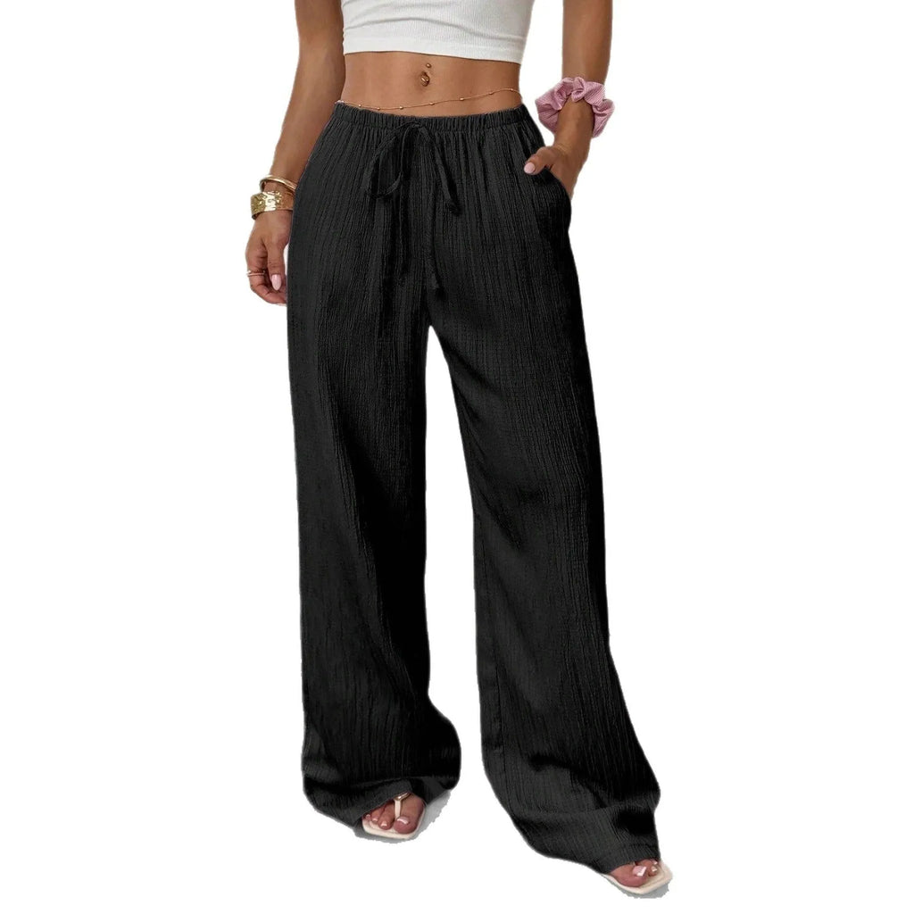 Women's black wide-leg trousers with a front lace-up waist detail on a neutral background.