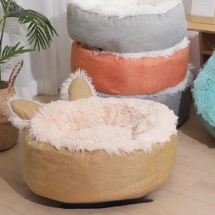 Round plush faux fur cat bed with raised sides in blue colour showing soft texture