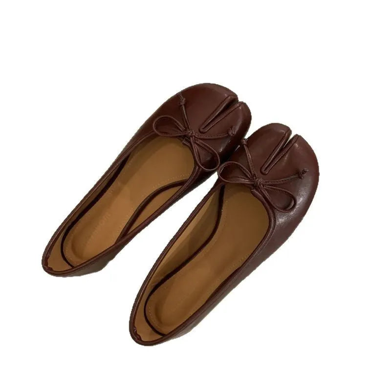 Women's split-toe flat pumps in beige with a round toe and flat rubber sole.