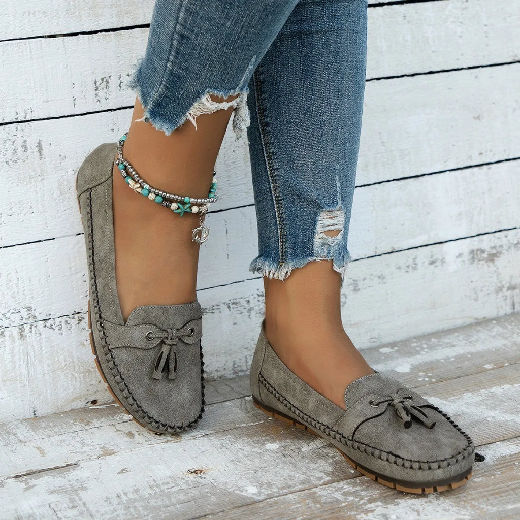 Women's casual suede flat shoes with a bow decoration, shown in a solid colour with a round toe and low heel.