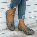 Women's casual suede flat shoes with a bow decoration, shown in a solid colour with a round toe and low heel.