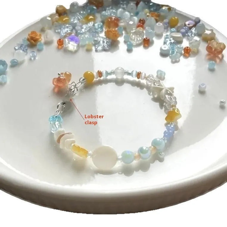 Orange mixed material women's bracelet with diamond shape and round decorative seaside elements.