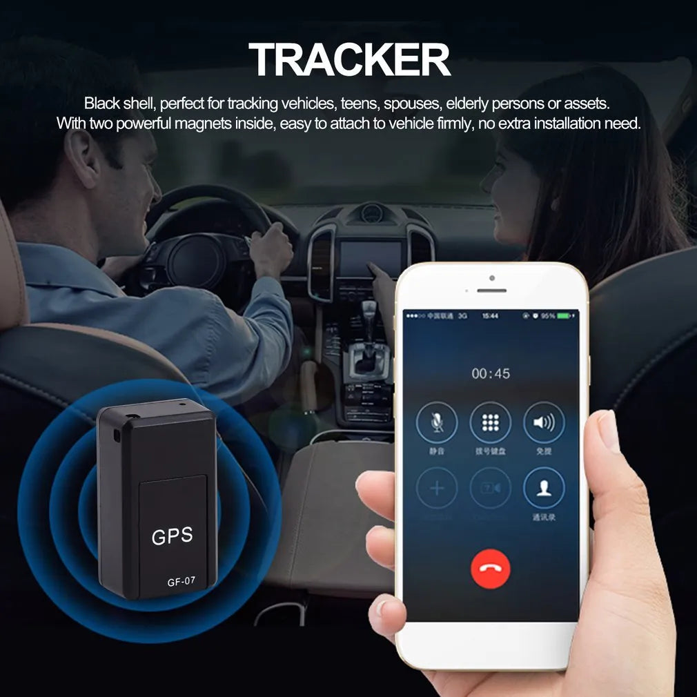 Small black magnetic GPS car tracker with USB charging cable on a metal surface.