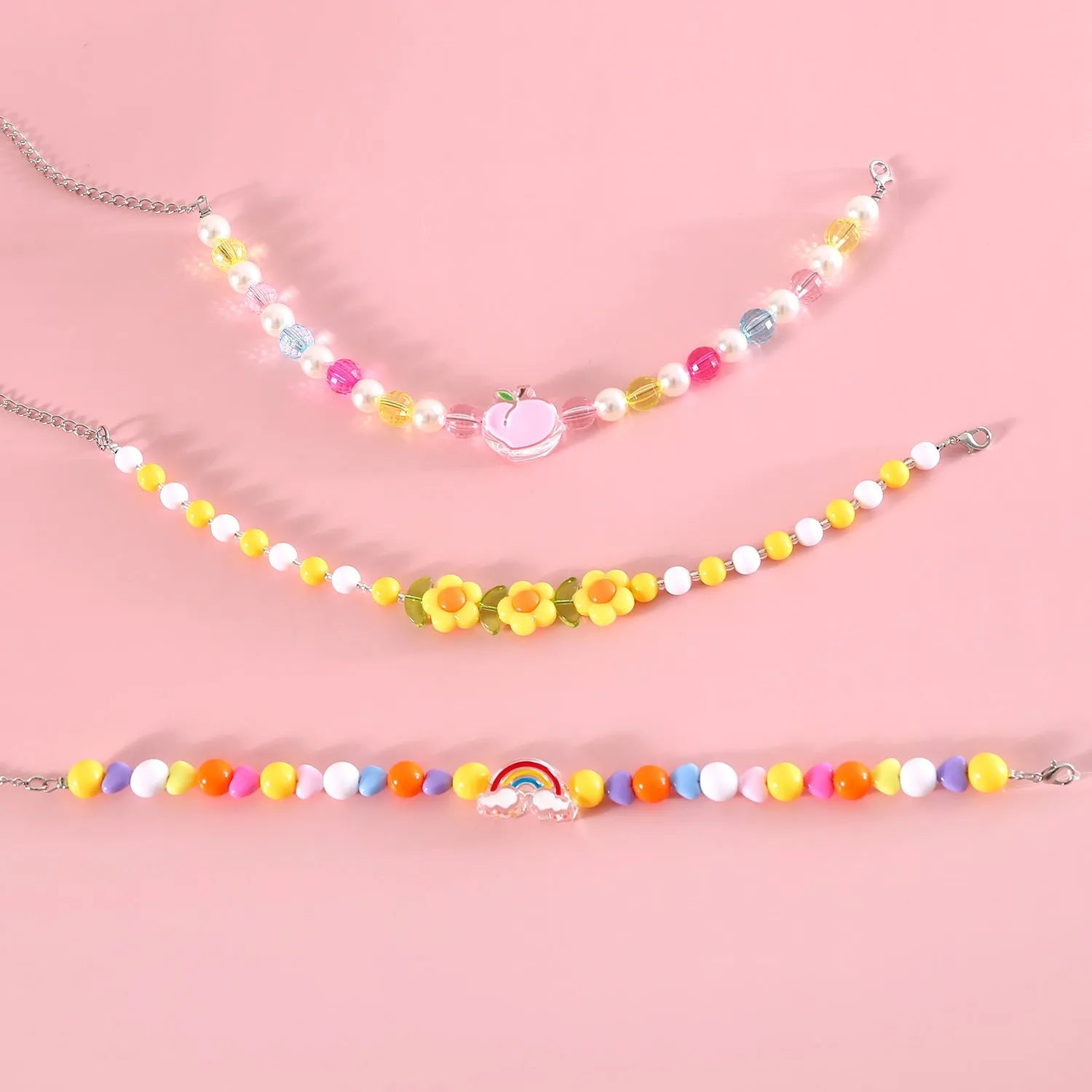 Colourful plastic bead pet necklace shown in peach, rainbow, and small flower patterns with an adjustable clasp.
