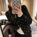 Women's grey dot print knitted cardigan with white crocheted flower detail on sleeve