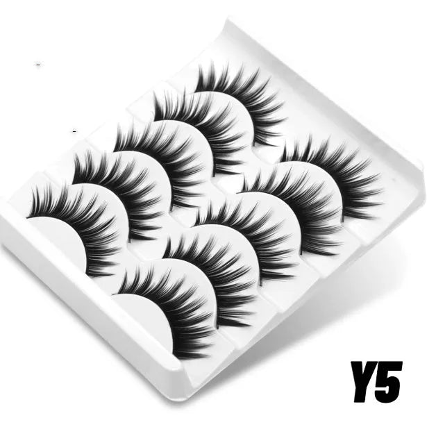 Box of artificial fibre false eyelashes in a natural long thick style with adhesive glue.
