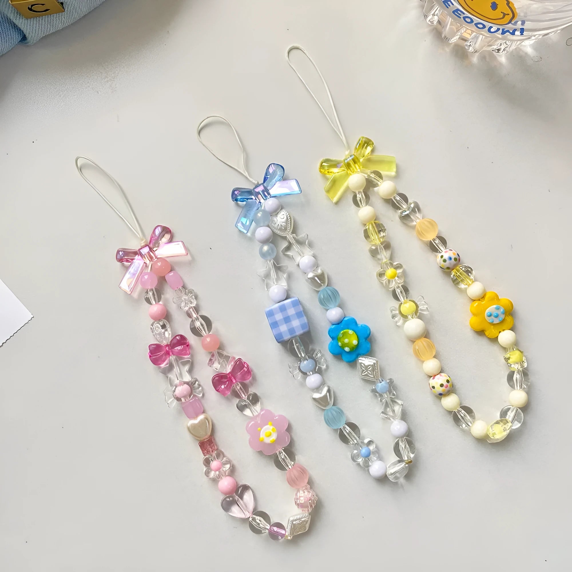 Yellow beaded flower mobile phone lanyard with plastic resin beads on a white background.