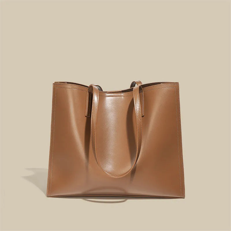 Women's brown genuine leather handbag with multiple internal pockets and single shoulder strap