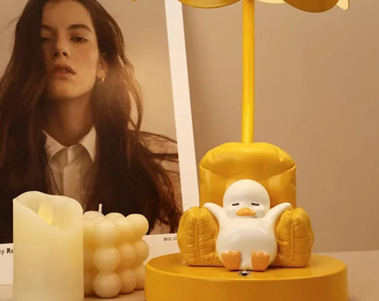 Cute yellow duck plastic night light table lamp with USB cable and gift box on a modern desk