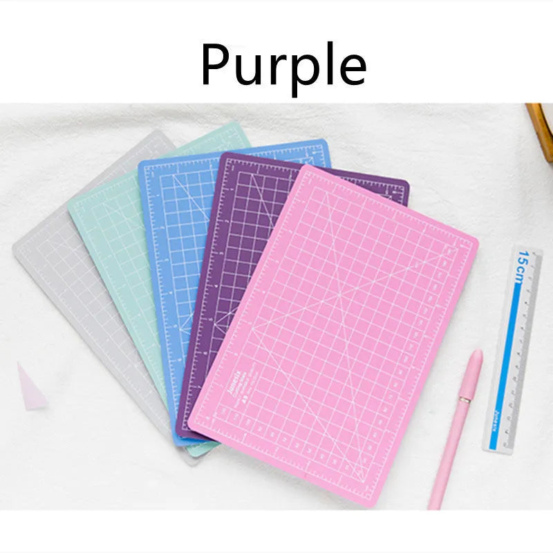 Art pen knife cutting board set showing plastic mat, metal ruler, sharpener and blade in assorted colours.