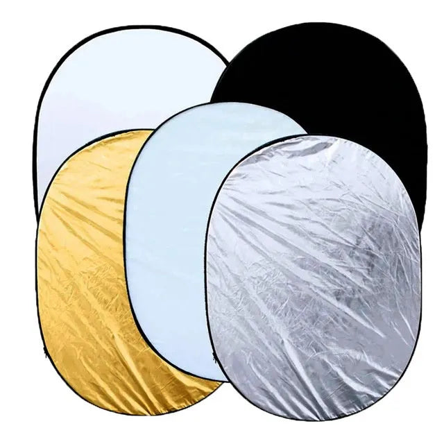 Collapsed 5-in-1 photography light reflector with gold, silver, white, black, translucent surfaces next to its carrying bag.