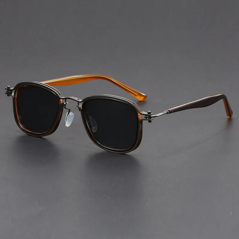 Retro square sunglasses with metal frame and tinted AC lenses in a two-tone colour option on a wooden surface.