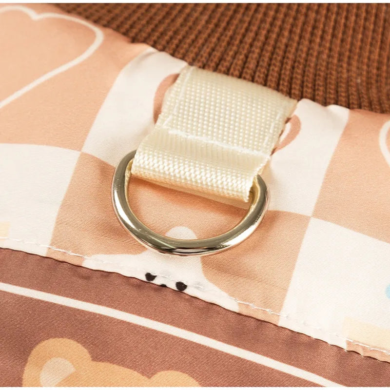 Quilted two-legged pet vest with leash ring in brown bear print or geometric red-green, sizes XS-XXL.
