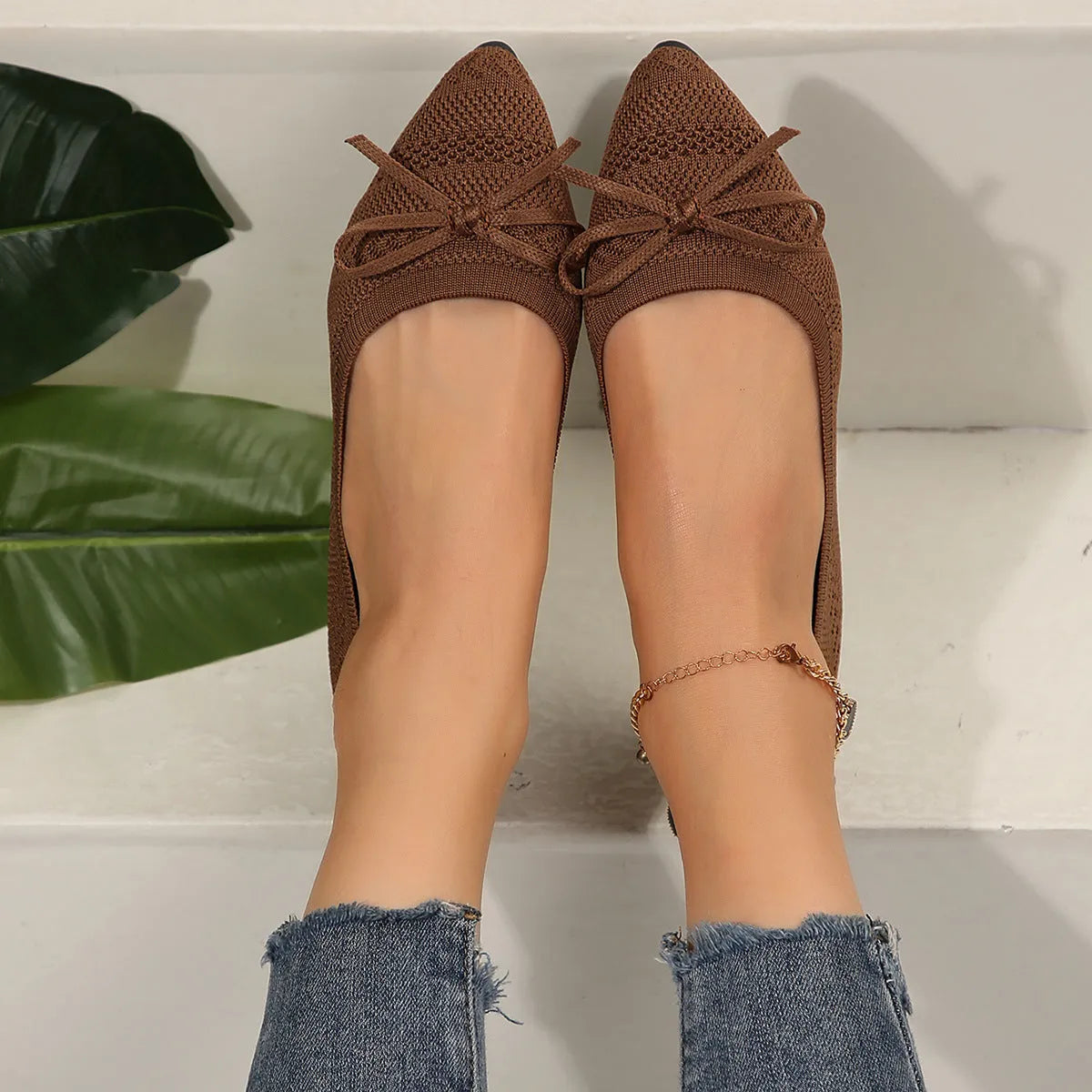 Women's blue knitted flat loafers with a pointed toe and a decorative bow on the front