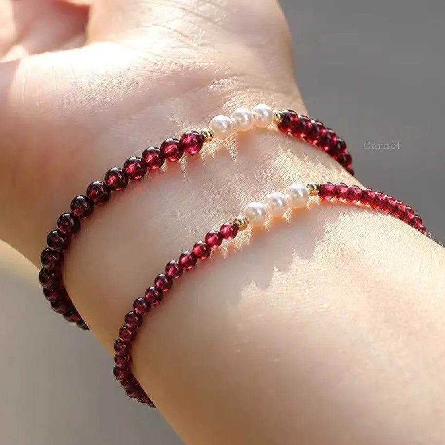Adjustable women's bracelet with garnet and artificial pearl beads on wrist