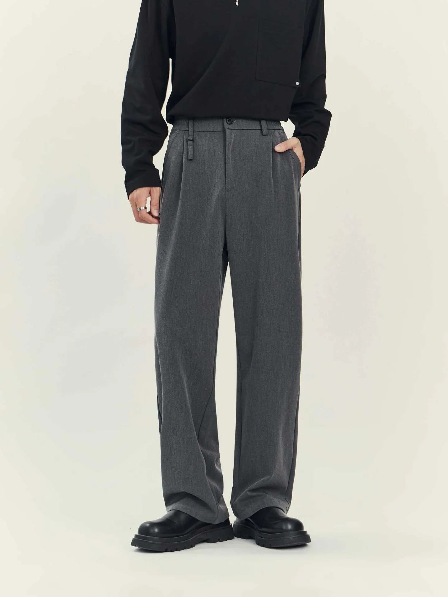 Black and grey loose straight-leg business casual trousers on a hanger, showing draping fit.