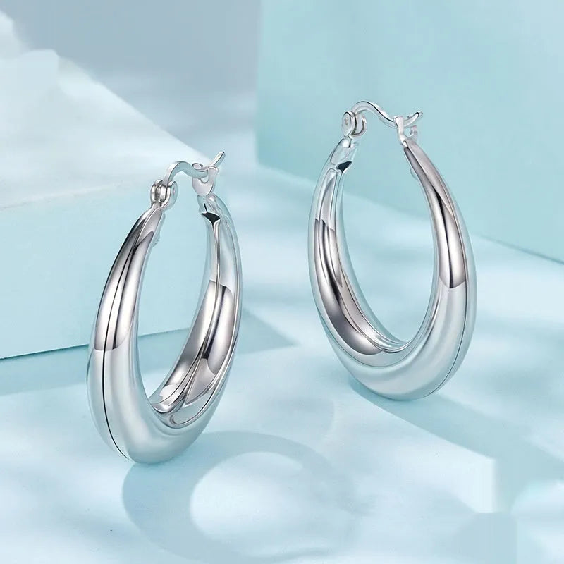 A pair of copper geometric ring ear clips with a silver needle, shown in large, medium, and small sizes.
