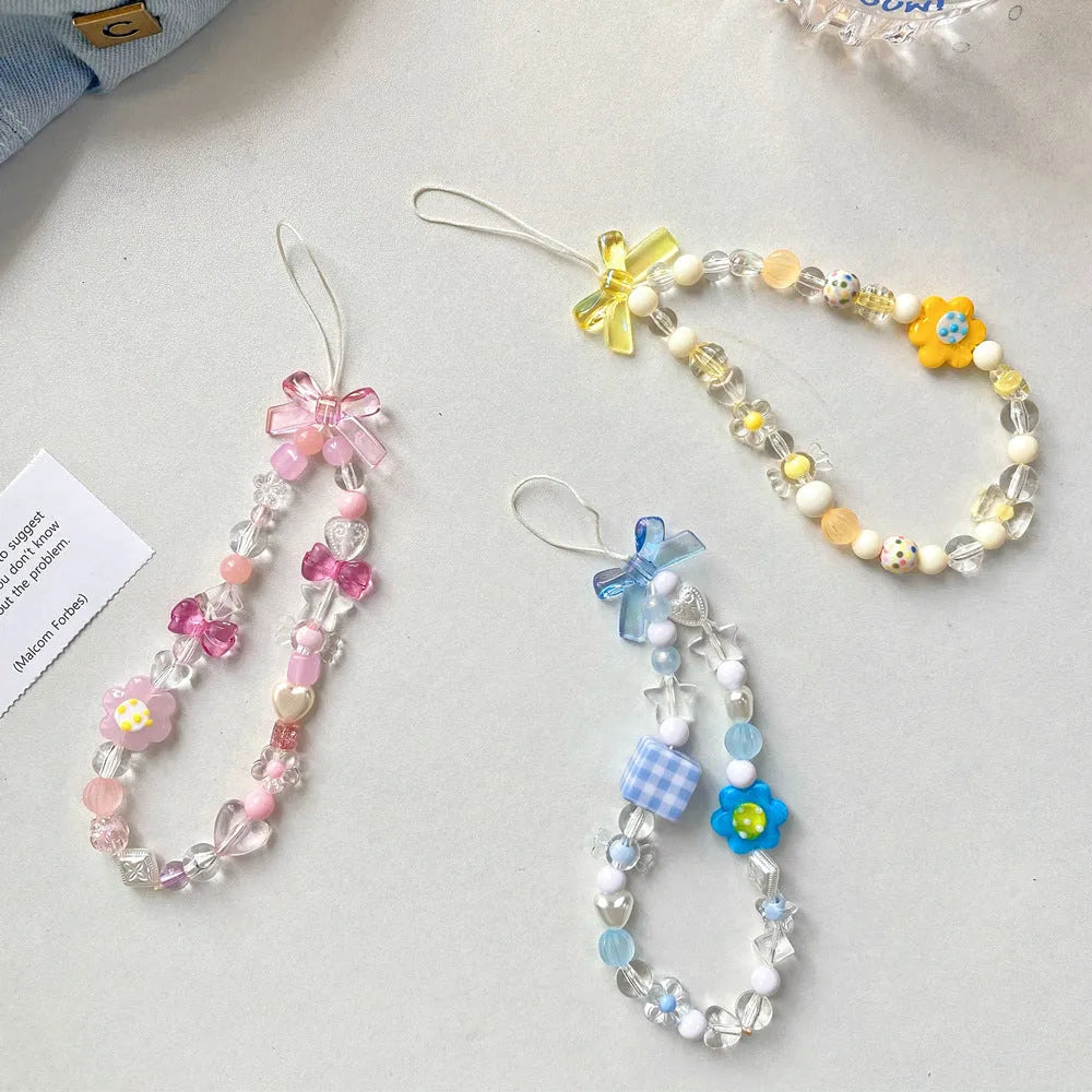 Yellow beaded flower mobile phone lanyard with plastic resin beads on a white background.