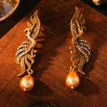 Pair of phoenix drop earrings in gold-tone electroplated alloy, hollow jeweled distressed design, 7cm by 1.6cm.