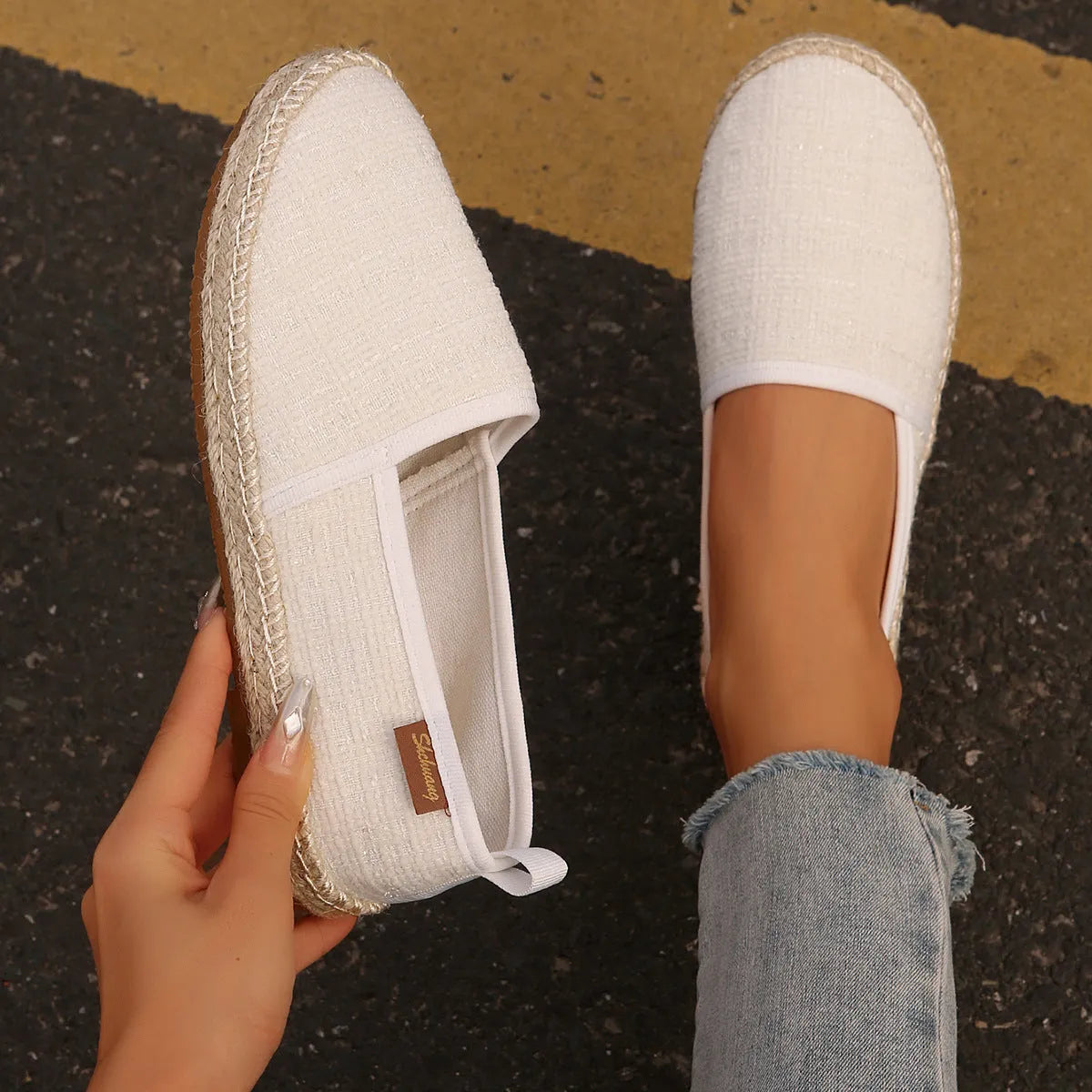 Casual beige canvas fisherman shoes with a textured rope sole on a wooden floor.