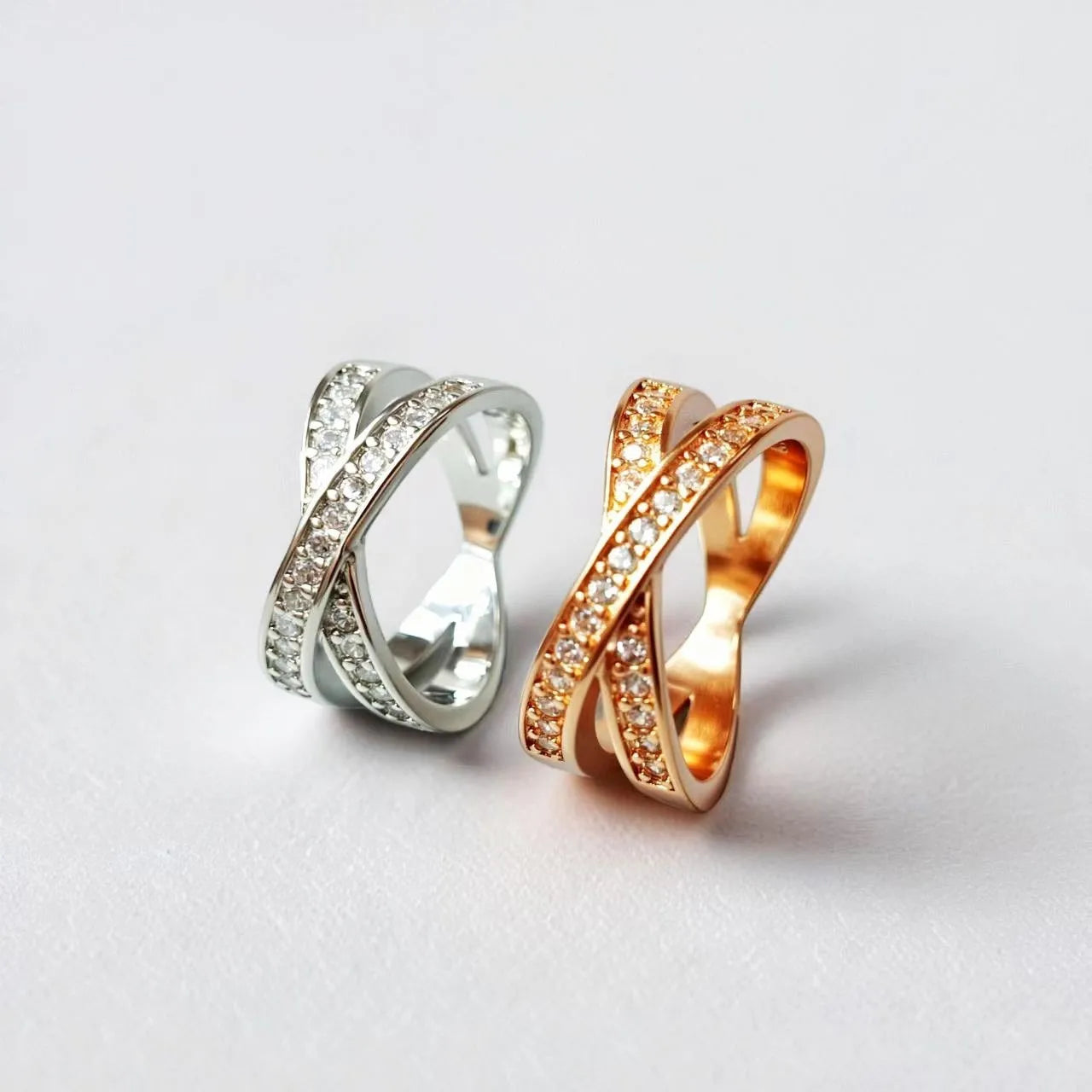 Close-up of a geometric cross ring on a hand, showing micro-inlaid zircon detail on a silver electroplated band.