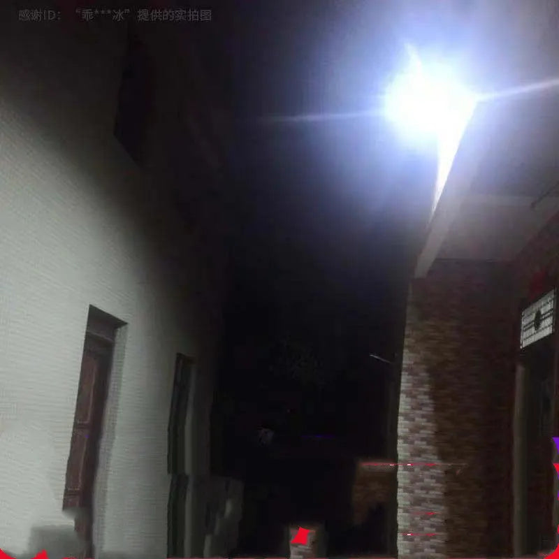 Black solar-powered LED flood light with motion sensor mounted on a wall bracket in a garden setting.