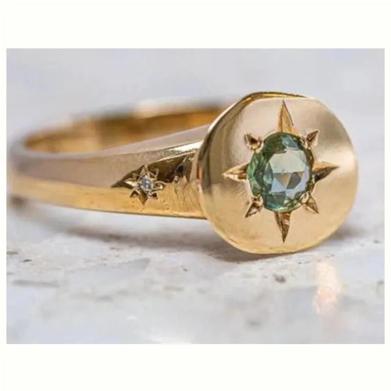 Golden adjustable ring with a star-shaped setting holding an oval zircon stone on a zinc alloy band.