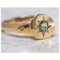 Golden adjustable ring with a star-shaped setting holding an oval zircon stone on a zinc alloy band.