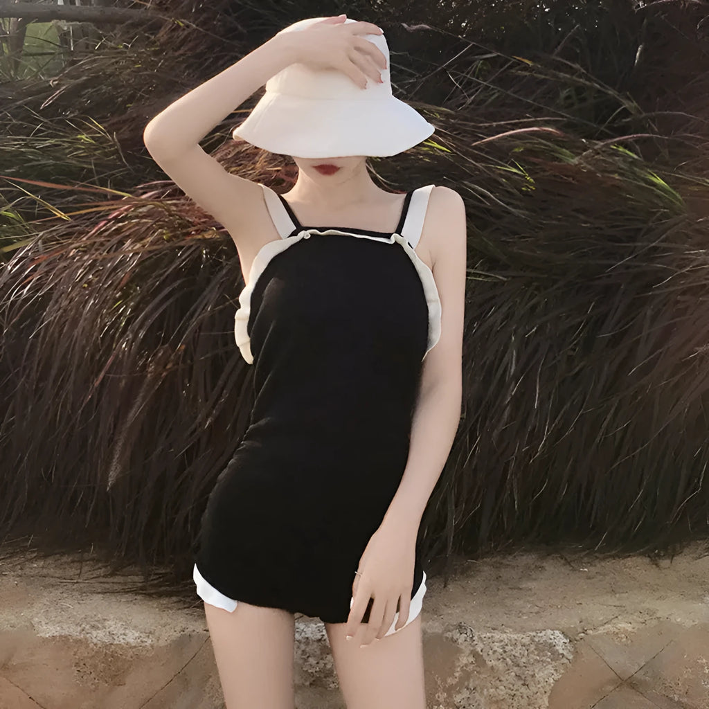 Women's conservative one-piece swimsuit in nylon, shown in black with white edge colour option.