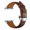 Genuine crocodile skin watch strap in brown with rose gold buckle, 42-44mm width, on a wooden surface