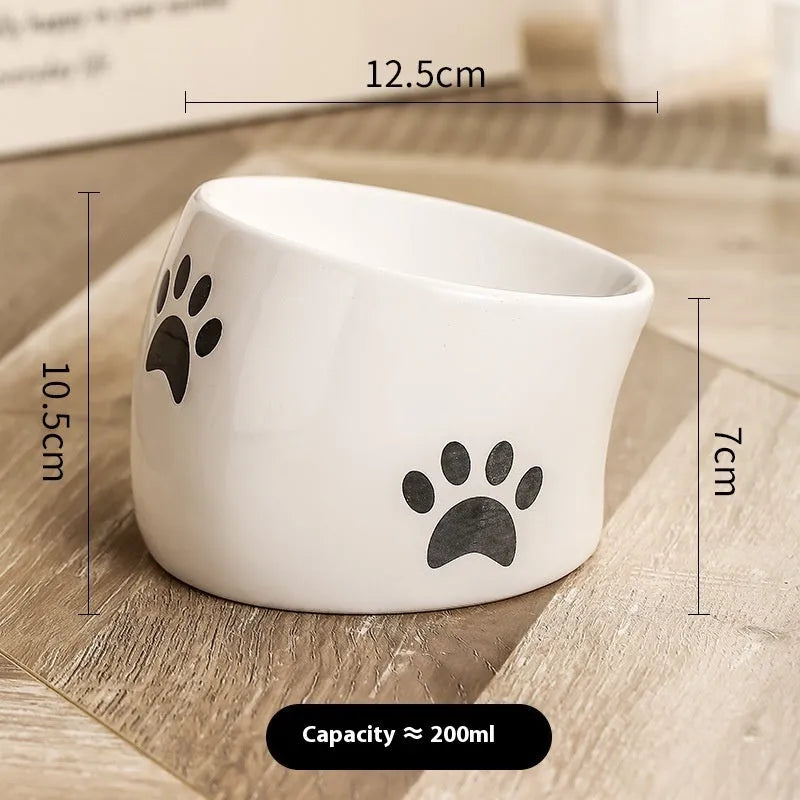 Ceramic cat bowl with cat paw design in black, showing oblique mouth style.