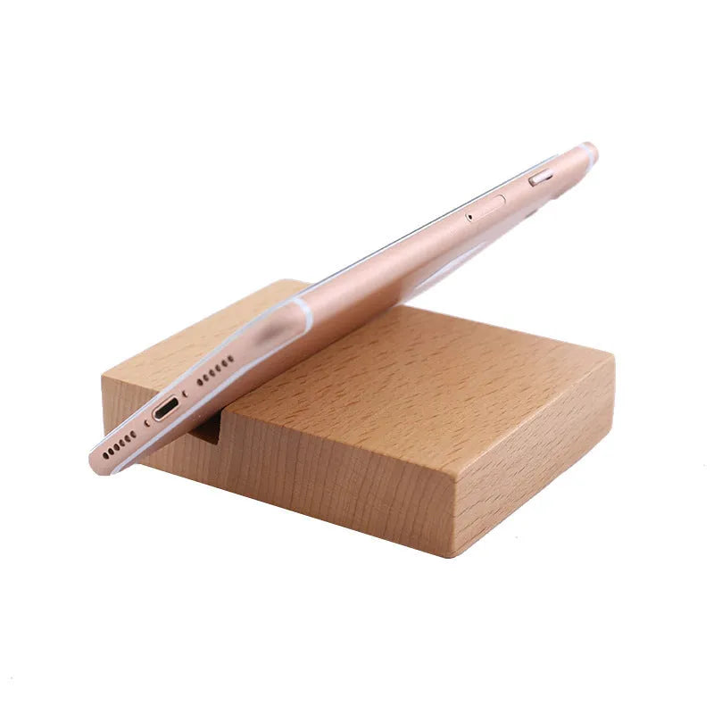 Sculpted beech wood lazy bracket phone holder with custom engraved text on a wooden desk.