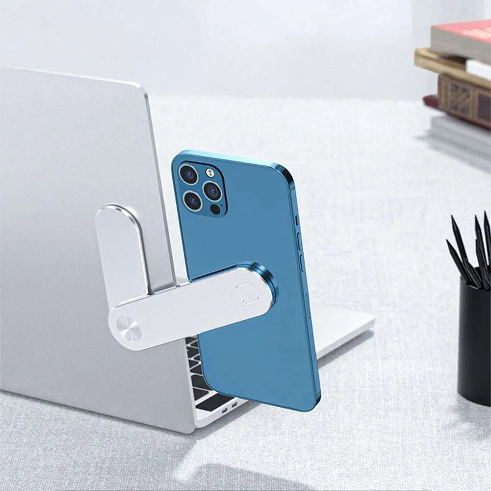 Black magnetic phone holder attached to side of silver laptop, showing phone mounted.