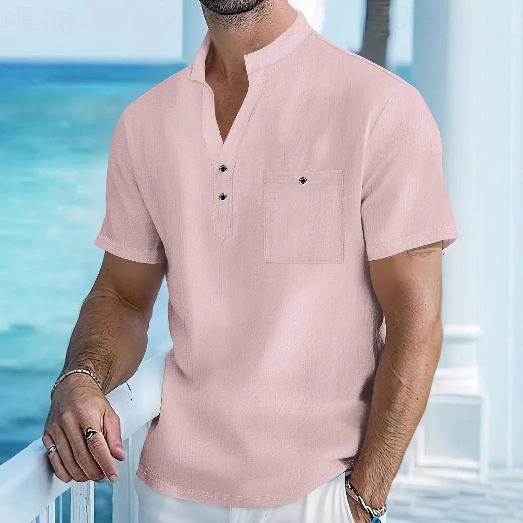 Man wearing a light blue stand collar linen blend t-shirt with short sleeves and a loose fit.