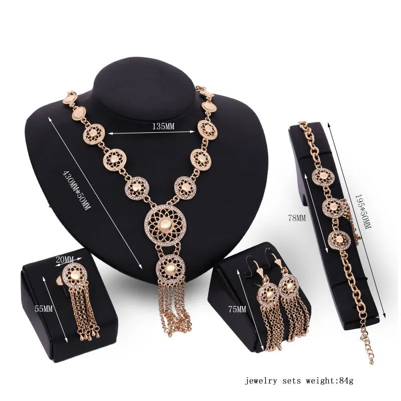 Gold alloy jewellery set with earrings, necklace, and bracelet featuring star and celestial pattern on a light background